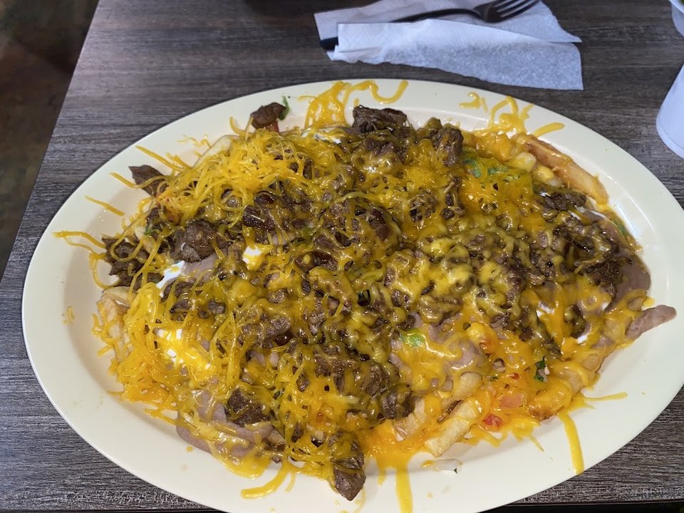 Printed menu with burritos, tacos, and plates.