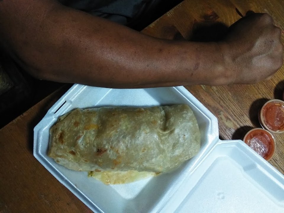 Printed menu with burritos, tacos, and plates.